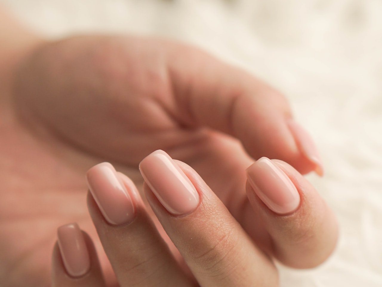 Close-up of glossy lilac gel manicure with chrome accents